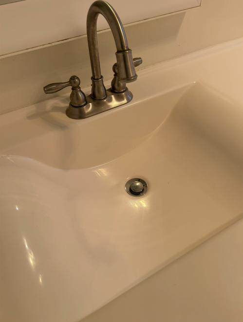 The same bathroom vanity sink spotless and shining after cleaning